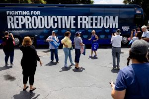 People take photos of the Reproductive Freedom Bus during the kickoff of the Harris-Walz campaign's reproductive rights bus tour in Boynton Beach, Florida, on Sept. 3.