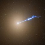 Hubble image of the giant galaxy M87 with a 3,000-light-year-long jet of plasma shooting out of the galaxy's central black hole. The jet, which looks like a blowtorch, appears to cause stars to erupt in its path