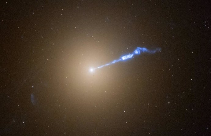 Hubble image of the giant galaxy M87 with a 3,000-light-year-long jet of plasma shooting out of the galaxy's central black hole. The jet, which looks like a blowtorch, appears to cause stars to erupt in its path