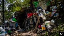 Dogs sit next to a damaged house where several people died after a rain-triggered landslide, in Naucalpan, Mexico, Tuesday, Sept. 17, 2024.