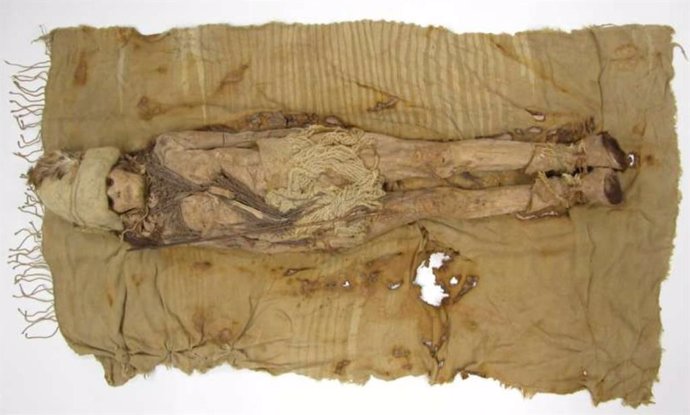 A mummy from Xiaohe Cemetery, and dairy remains are scattered around the mummy's neck.