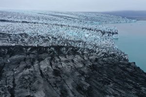 The receding Breidamerkurjokull glacier, part of which is black with dust and volcanic rocks, ends in Jokulsarlon lake on August 15, 2021 near Hof, Iceland.