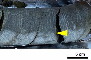 This photograph was taken on site when the drill core sample was washed, flamed, and then cracked. The 30 centimeters long and 85 millimeters diameter core was taken back to Japan for further study.