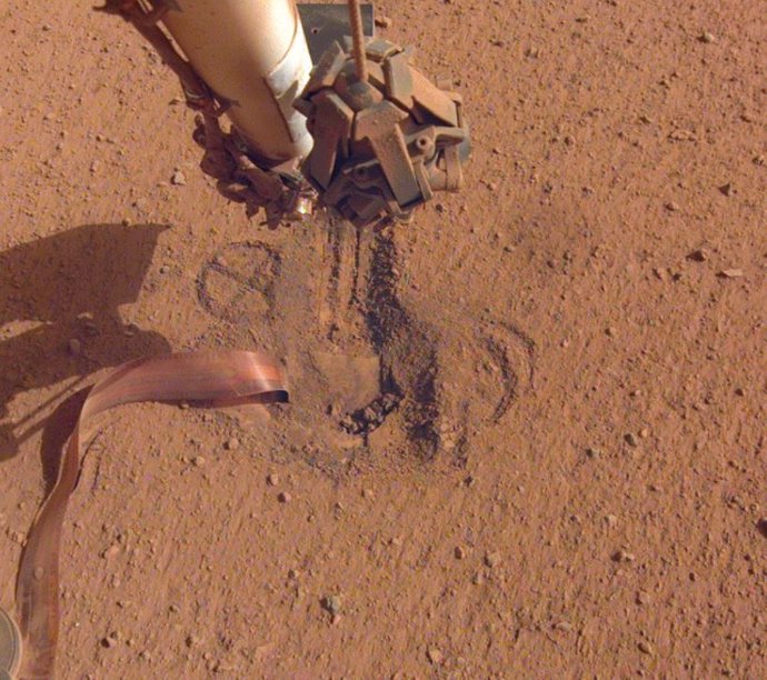 File - NASA's InSight retracted its robotic arm on October 3, 2020, revealing where the "mole" spike-shaped is trying to dig into Mars.