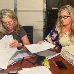 Angela Williams and Andrea Lynn, from left, with stacks of documents related to their father's case.