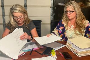 Angela Williams and Andrea Lynn, from left, with stacks of documents related to their father's case.