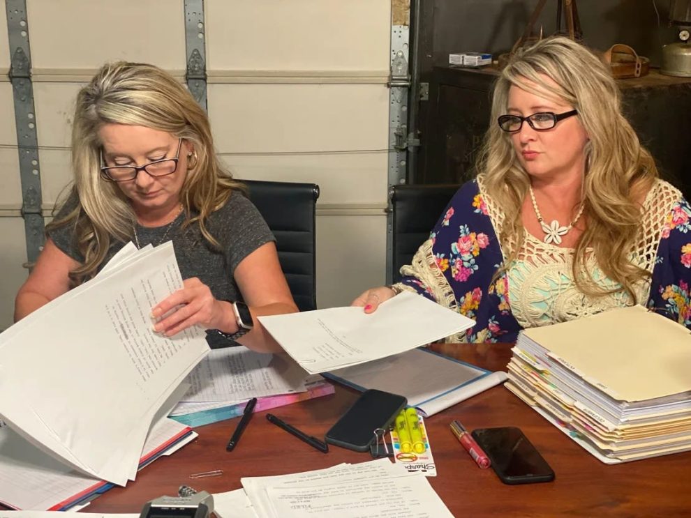 Angela Williams and Andrea Lynn, from left, with stacks of documents related to their father's case.