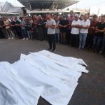 A group of people pray to their dead - victims of Israel's attacks - at the doors of a hospital in Gaza.