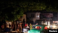 Cuban police and military stand next to debris used to block a street during a protest against a blackout, after opening the street to traffic, in Havana, Cuba, on October 19, 2024.