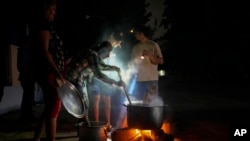 FILE - Residents prepare soup over a stove during a blackout following the failure of a major power plant in Havana, Cuba, on Oct. 19, 2024.