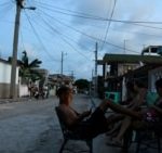 FILE - People sit outside their homes during a power outage caused by breakdowns that forced six plants to disconnect from the grid, according to the state electricity company, in Matanzas, Cuba, August 22, 2024. REUTERS/Norlys Perez.