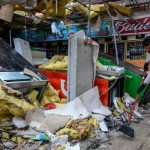 A man clears debris inside a gas station store in Lakewood Park, Florida, after a tornado hit the area as Hurricane Milton moved through the region on October 10, 2024.