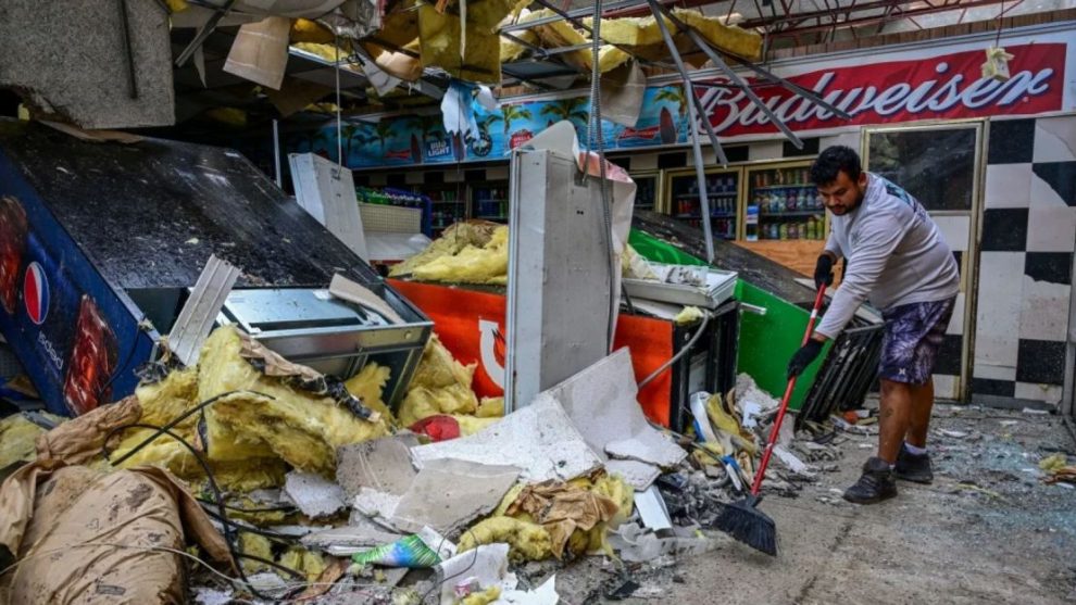 A man clears debris inside a gas station store in Lakewood Park, Florida, after a tornado hit the area as Hurricane Milton moved through the region on October 10, 2024.