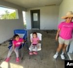 Elizabeth with her two daughters on the porch of her home in Fort Myers, Florida, hours after Hurricane Milton hit. [Foto: Antoni Belchi/VOA]