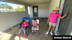 Elizabeth with her two daughters on the porch of her home in Fort Myers, Florida, hours after Hurricane Milton hit. [Foto: Antoni Belchi/VOA]