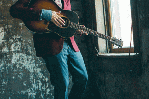 John Hiatt holds a guitar while looking out the window. (Courtesy photo)