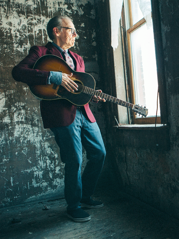 John Hiatt holds a guitar while looking out the window. (Courtesy photo)