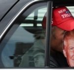 FILE - A person holds a Trump mask inside a vehicle on the day former U.S. President Donald Trump appears in U.S. District Court in Washington, Aug. 3, 2023.