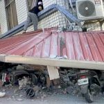 In this image taken from a video broadcast by TVBS, a man checks a partially collapsed building in Hualien, eastern Taiwan, on Wednesday, April 3.