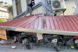 In this image taken from a video broadcast by TVBS, a man checks a partially collapsed building in Hualien, eastern Taiwan, on Wednesday, April 3.