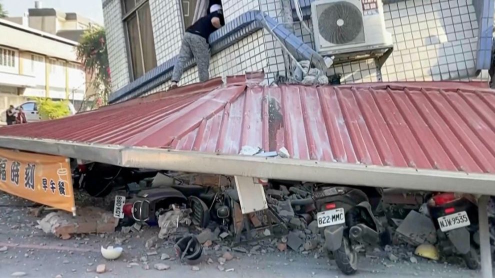 In this image taken from a video broadcast by TVBS, a man checks a partially collapsed building in Hualien, eastern Taiwan, on Wednesday, April 3.