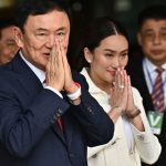 Former Thai Prime Minister Thaksin Shinawatra greets supporters, along with his youngest daughter Paetongtarn Shinawatra, at Don Mueang Airport in Bangkok on August 22, 2023.