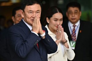 Former Thai Prime Minister Thaksin Shinawatra greets supporters, along with his youngest daughter Paetongtarn Shinawatra, at Don Mueang Airport in Bangkok on August 22, 2023.