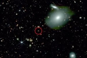 Webb shows an ancient quasar (circled in red) with fewer neighboring galaxies than expected (bright spheres), challenging physicists' understanding of how the first quasars and supermassive black holes formed.