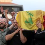 File image of several men carrying a coffin covered with the Hezbollah flag during a funeral.