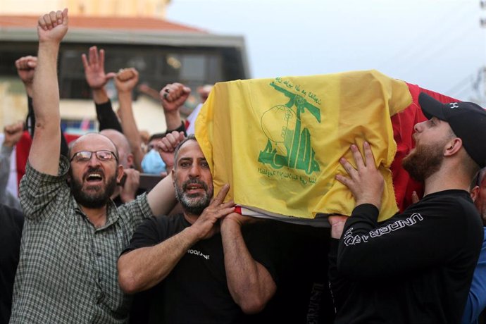 File image of several men carrying a coffin covered with the Hezbollah flag during a funeral.