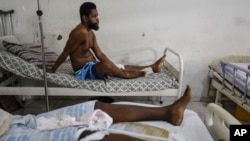 Exiles Junior, wounded by a bullet during armed gang attacks, sits on a bed at the Saint Nicolas hospital in Saint-Marc, Haiti, Sunday, October 6, 2024.