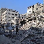 Archive - Palestinians walk between buildings destroyed by the Israeli Army's attacks on the city of Beit Lahia, in the north of the Gaza Strip (archive)