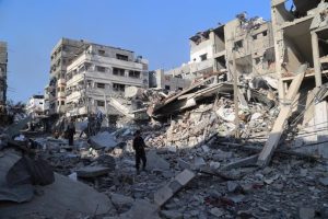 Archive - Palestinians walk between buildings destroyed by the Israeli Army's attacks on the city of Beit Lahia, in the north of the Gaza Strip (archive)