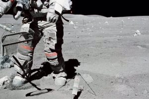 Astronaut John W. Young collects samples of lunar regolith.