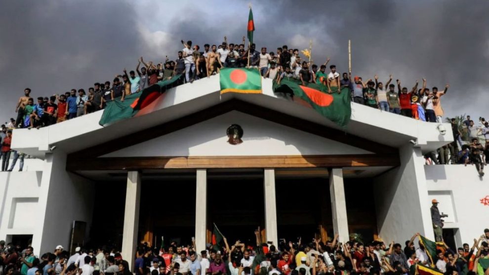 Anti-government protesters display Bangladesh's national flag after storming former Prime Minister Sheikh Hasina's palace in Dhaka on August 5, 2024.