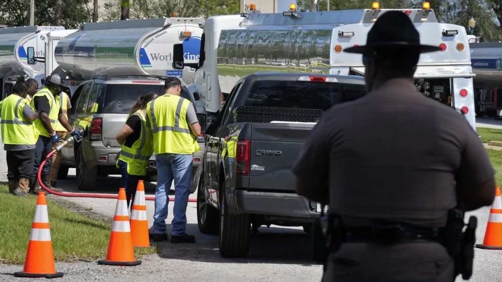 A Florida Highway Patrol trooper watches as workers at a fuel depot distribute gasoline to residents on Saturday, Oct. 12, 2024, in Plant City, Florida. Credit: Chris O'Meara/AP