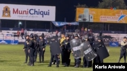 FILE - An anti-riot group guards the team of referees trying to leave the Las Victorias stadium, in Chiquimula, Guatemala, while attendees of the match between Sacachispas and Suchitepéquez wait to boo them, on November 16, 2024.