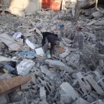 Several people search through the rubble of a building destroyed in an Israeli airstrike