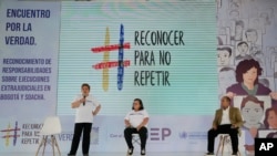 FILE - Carmenza Gómez (left), and Gloria Martínez (center), relatives of those murdered by extrajudicial execution in 2008, attend a reconciliation event with retired general Paulino Coronado (right), in Soacha, Colombia, on May 10, 2022.