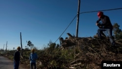 Workers repair power lines damaged during Hurricane Rafael in Caimito, Cuba, on November 18, 2024