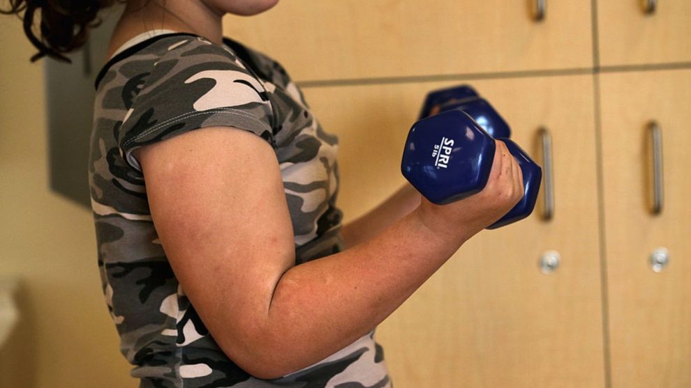 AURORA, CO - NOVEMBER 20: Zoe McCoy, 9, lifts weights in exercise class during the Shapedown program for overweight adolescents and children on November 20, 2010 in Aurora, Colorado. The 10-week family-centered program held by the Denver area Children's Hospital teaches youth and their parents ways to lead a healthier more active lifestyle, as a longer lasting weight-loss alternative to dieting. Nationally, some 15 percent of children are overweight or obese, as are some 60 percent of adults. (Photo by John Moore/Getty Images)