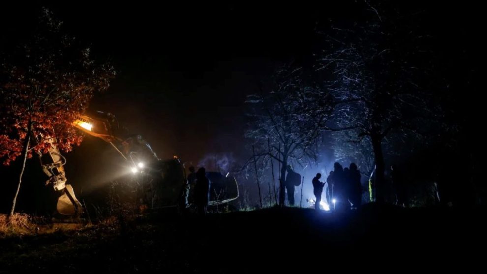 People stand near the damaged canal in northern Kosovo that supplies water to two coal-fired power plants that generate almost all of the country's electricity, in Varage, Kosovo, on November 30, 2024.