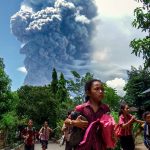 Schoolchildren in the Indonesian village of Lewolaga run during the eruption of Mount Lewotobi Laki-Laki on Thursday, November 7.