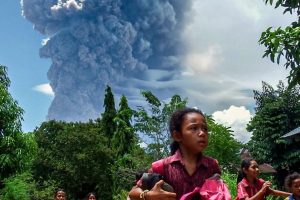 Schoolchildren in the Indonesian village of Lewolaga run during the eruption of Mount Lewotobi Laki-Laki on Thursday, November 7.