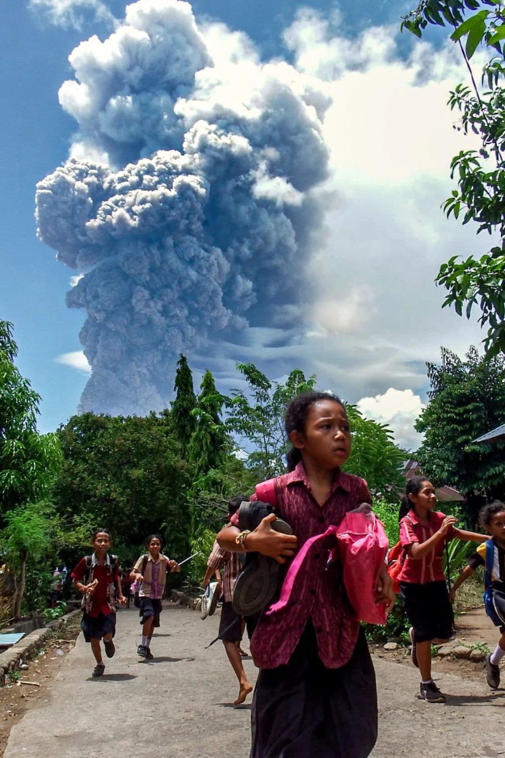 Schoolchildren in the Indonesian village of Lewolaga run during the eruption of Mount Lewotobi Laki-Laki on Thursday, November 7.