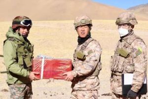 Indian and Chinese soldiers exchange sweets as part of overcoming the border conflict