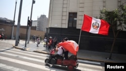 A protester holds a Peruvian flag at a protest in front of Congress as transporters demand greater protection amid a wave of extortions and attacks in Lima, Peru, on October 23, 2024.