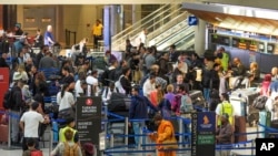 International passengers line up to check in for travel at Los Angeles International Airport in Los Angeles, Wednesday, Nov. 27, 2024. (AP Photo/Damian Dovarganes)