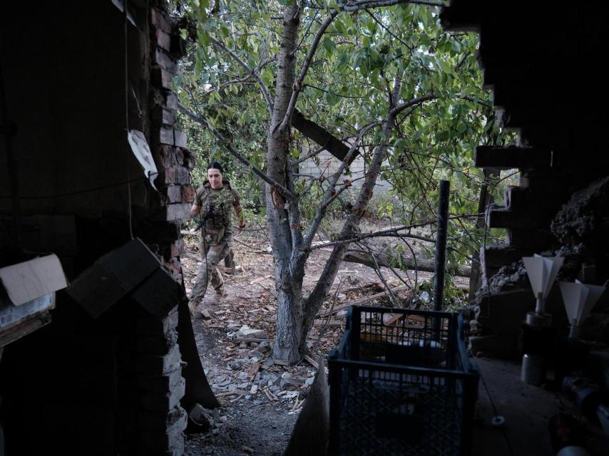 Private Anna, from the Ukrainian 120th Reconnaissance Regiment, picks up her attack drone after a flight, inside the town of Chasiv Yar.