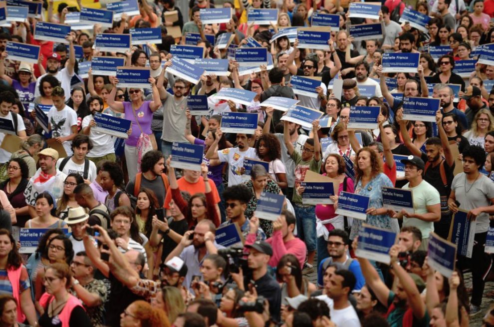 Protesters hold signs in the streets that say